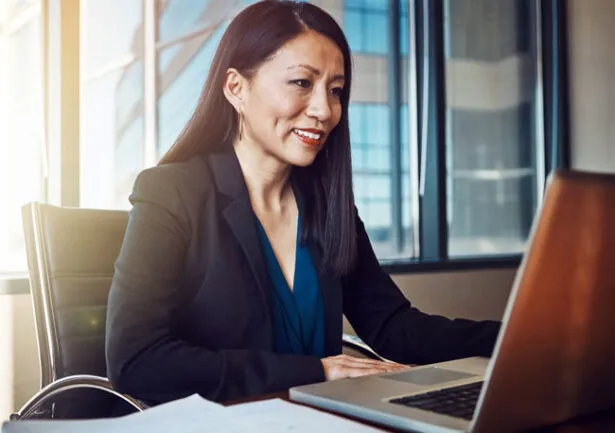 A law office owner reviews her firm’s fleet card analytics at a computer.