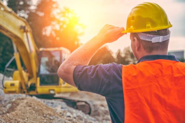 A construction worker at a commercial construction site near a vehicle requiring fuel.