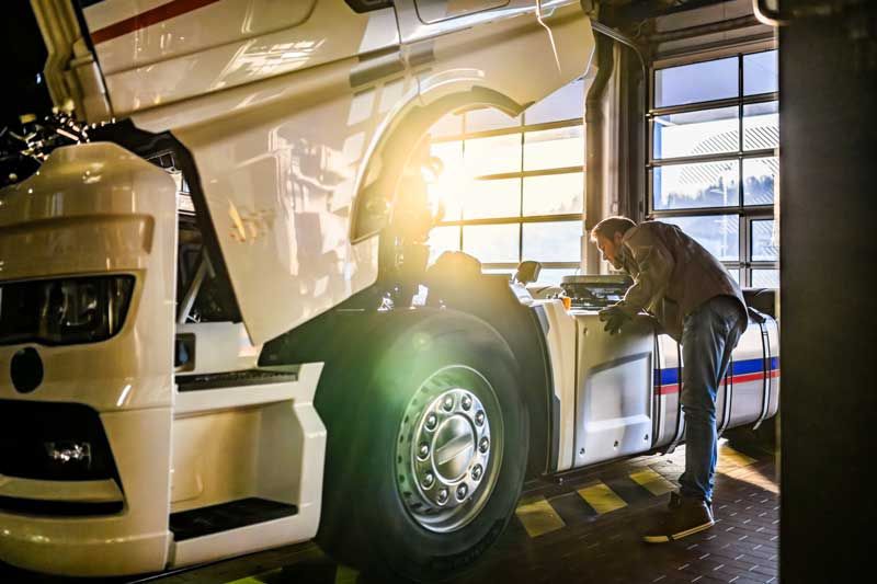 A semi truck mechanic maintains a truck from a fleet.